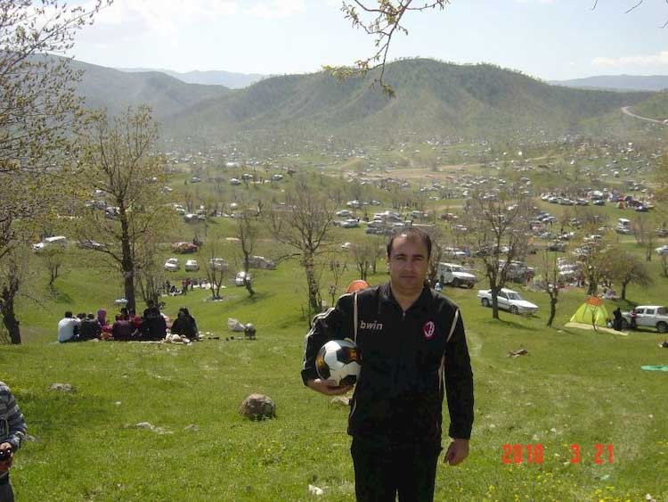 Man in hills holding soccer ball