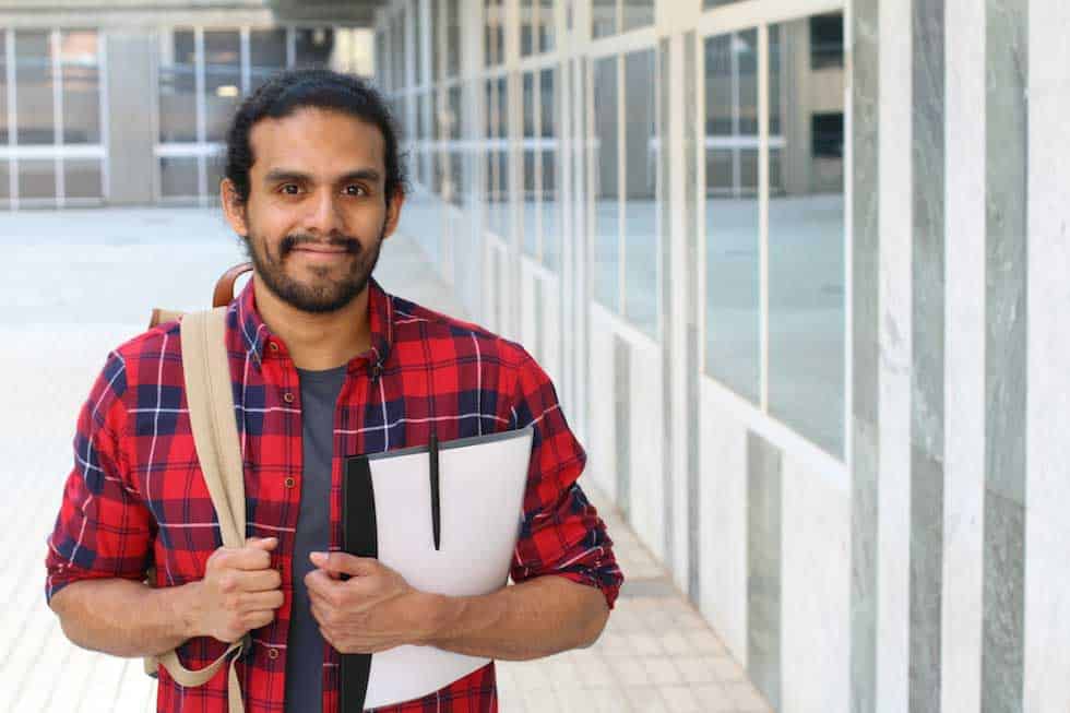 hombre vestido con camisa a cuadros en un campus