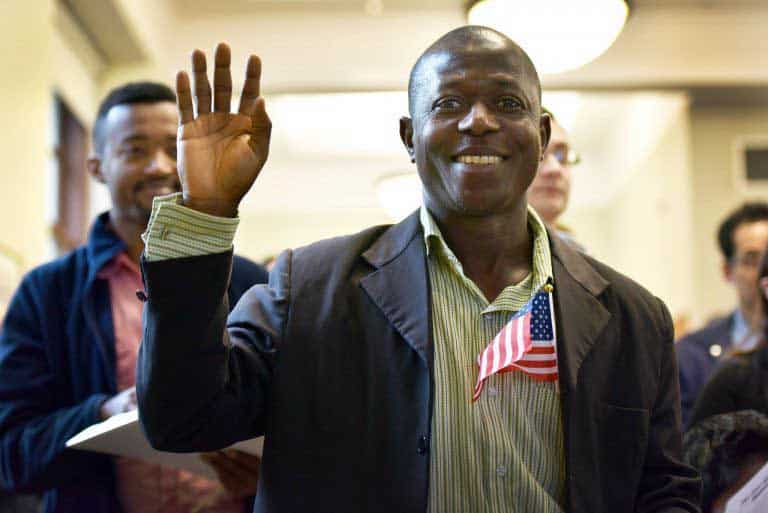 A man with a US flag raising hand for pledge