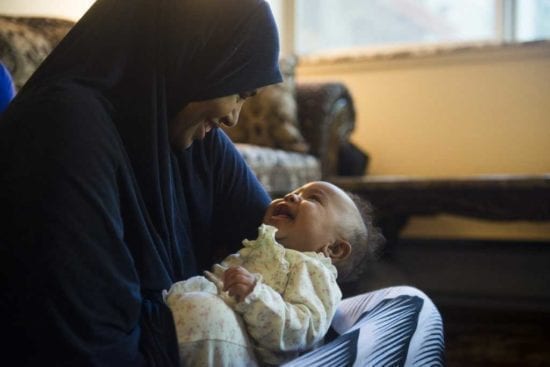 mother smiles at baby in her lap