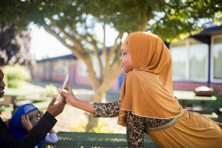 young girl showing smartphone to man