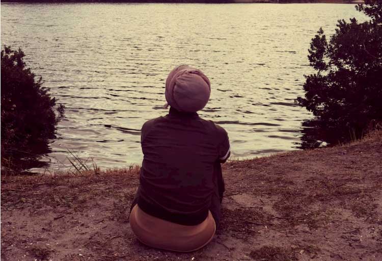 rear view of Basma Alawee sitting by water