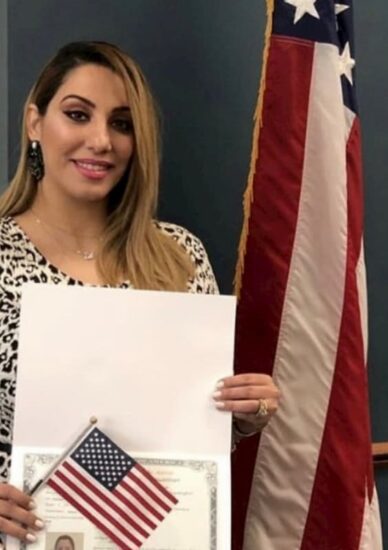 Woman with naturalization certificate with US flag