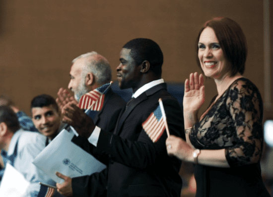 woman waving at citizenship ceremony