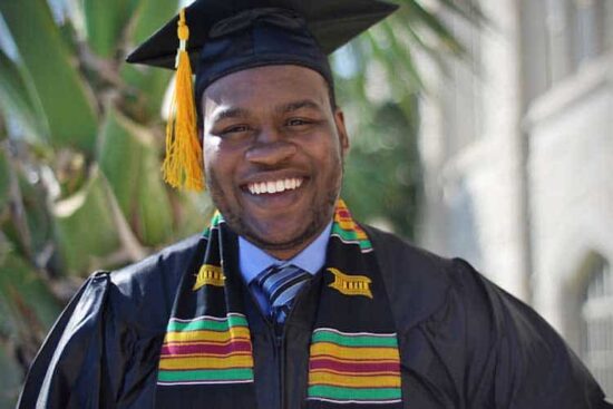 smiling male graduate with yellow tassel